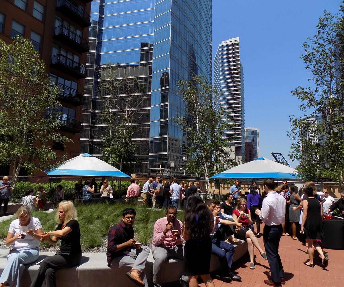 A crowd gathers for an event in the 150 Riverside courtyard